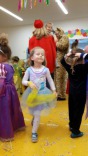 Kleines Mädchen als Prinzessin verkleidet tanzt durch die Turnhalle.