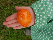Kinderhand hält ein leuchtend buntes Ei